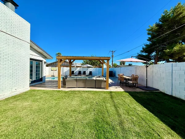 a view of a house with backyard sitting area and garden