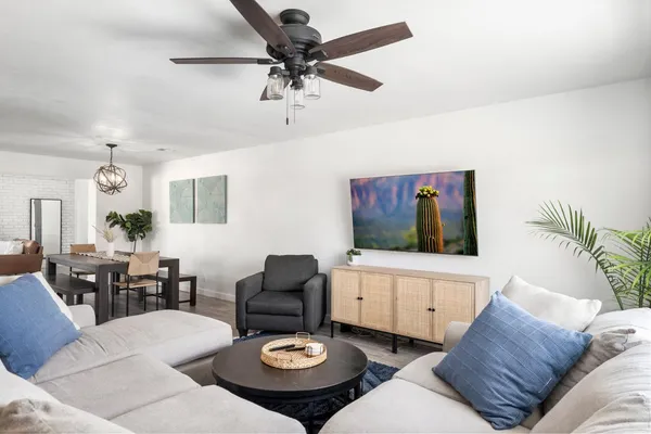a living room with furniture kitchen view and a flat screen tv