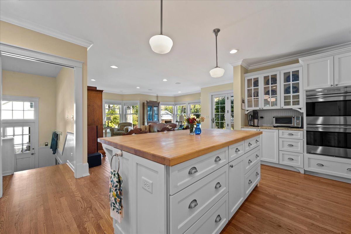 611 Ash Street Winnetka, IL 60093 - Photo 12 of 43 a kitchen with kitchen island granite countertop a sink cabinets and wooden floor