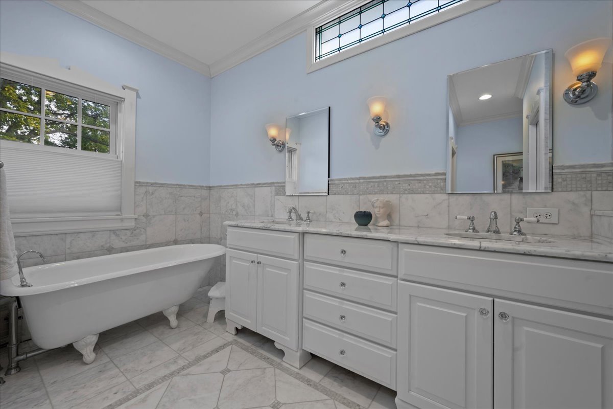 611 Ash Street Winnetka, IL 60093 - Photo 29 of 43 a bathroom with a double vanity sink a mirror and a bathtub