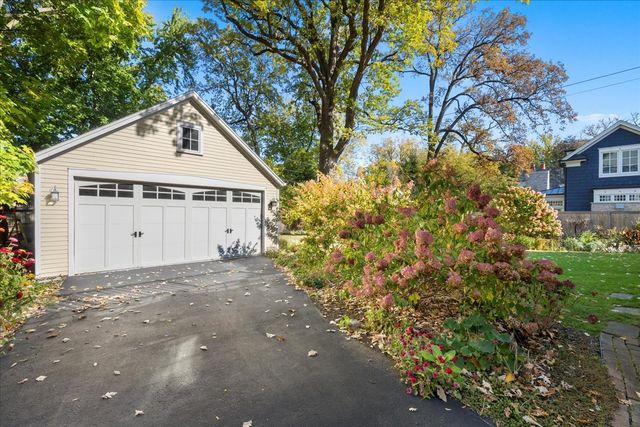 a view of a white house with a yard and large tree