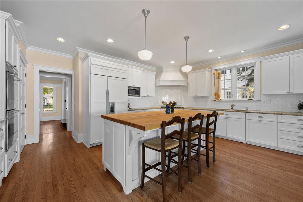 611 Ash Street Winnetka, IL 60093 - Photo 5 of 43 a kitchen with stainless steel appliances a dining table chairs stove refrigerator and cabinets