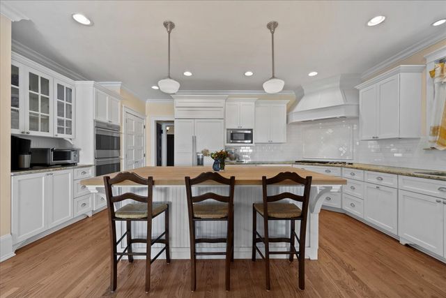 a kitchen with cabinets table and chairs