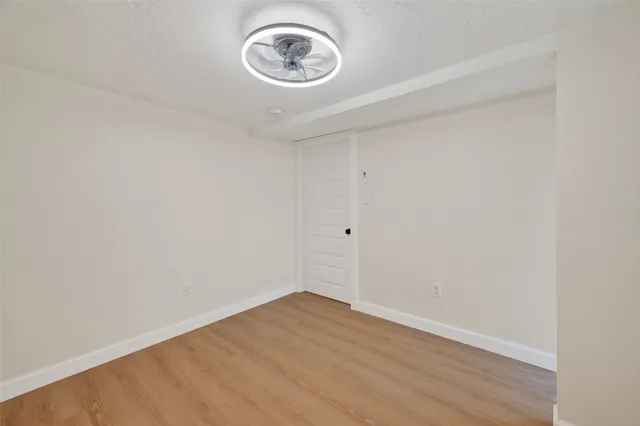 a view of a room with wooden floor and a window