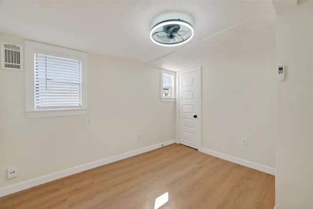 an empty room with a wooden floor and a window