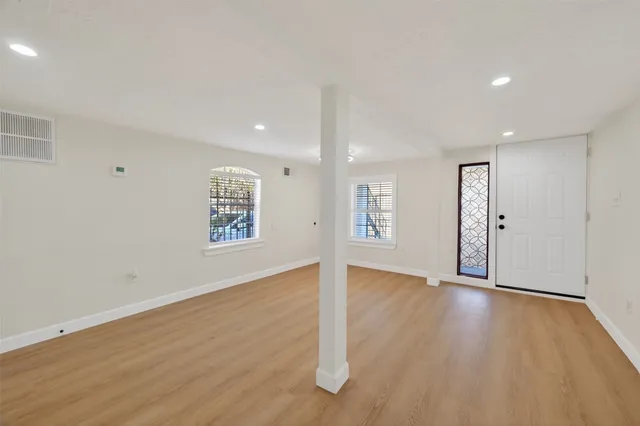 a view of an empty room with wooden floor
