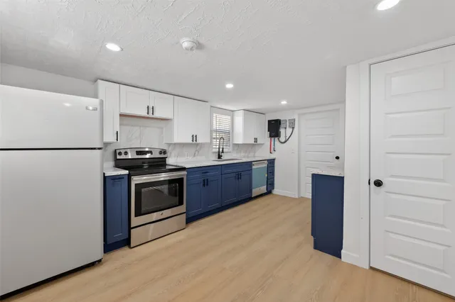 a kitchen with stainless steel appliances granite countertop a refrigerator and a stove top oven