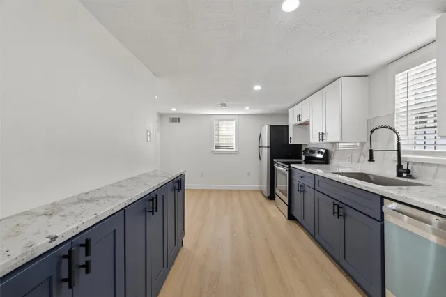 a kitchen with granite countertop a sink and cabinets