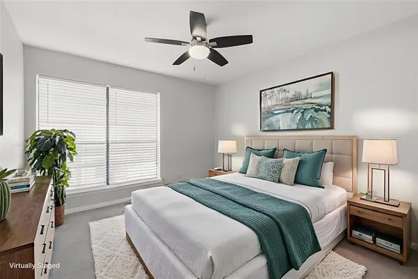 a bedroom with a bed and a large window