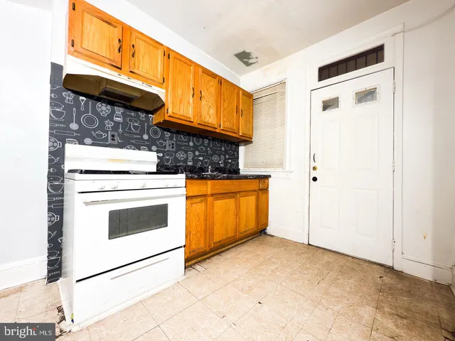a kitchen with granite countertop cabinets stainless steel appliances a sink and a window