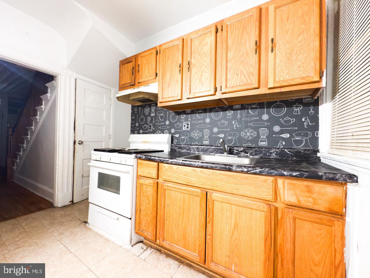 711 Florida Avenue Northeast Washington, DC 20002 - Photo 16 of 46 a kitchen with granite countertop cabinets stainless steel appliances a sink and a window