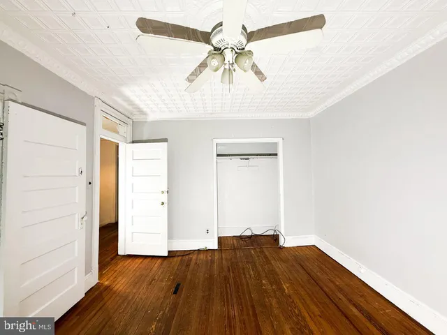a view of a livingroom with wooden floor and a ceiling fan