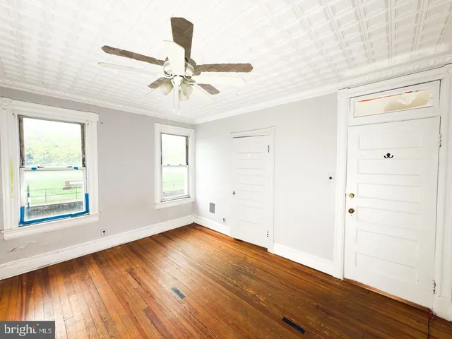 a view of empty room with wooden floor
