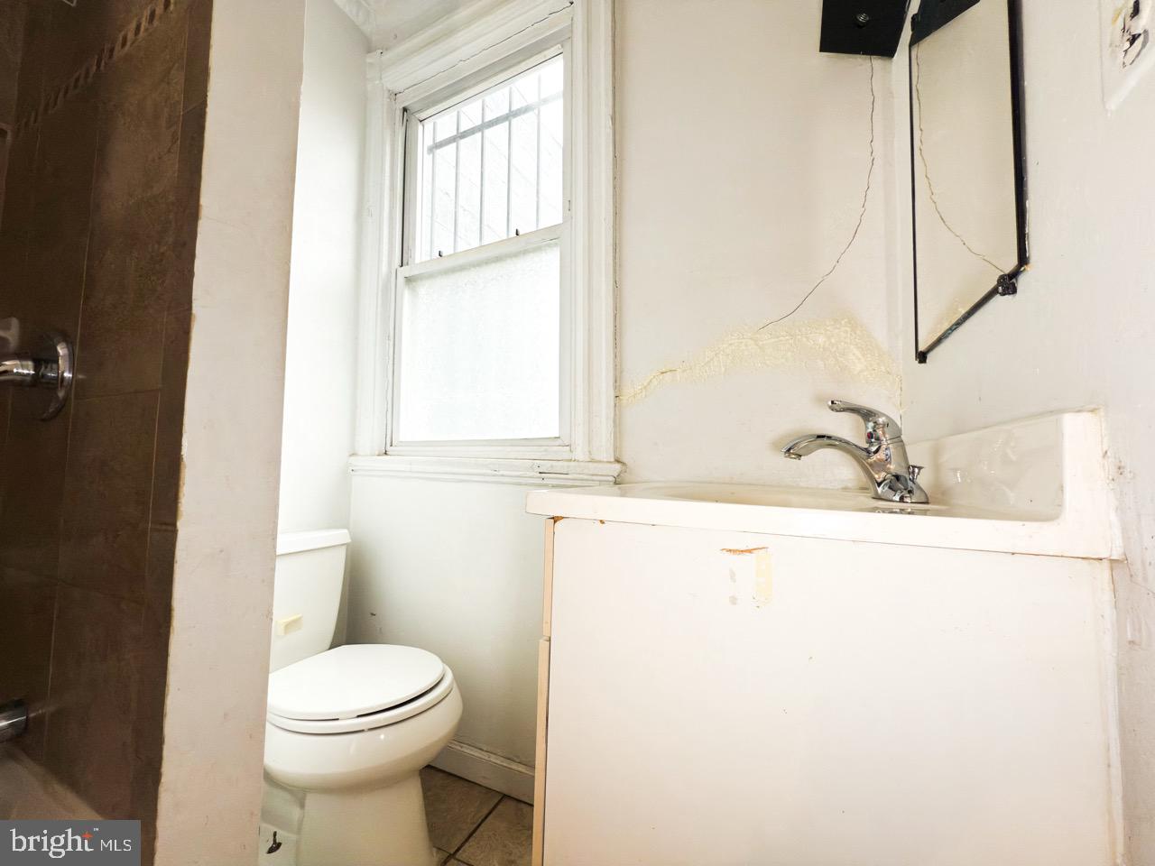 711 Florida Avenue Northeast Washington, DC 20002 - Photo 27 of 46 a bathroom with a sink a toilet and a window