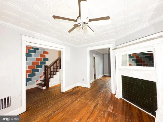 a view of a livingroom with wooden floor and staircase