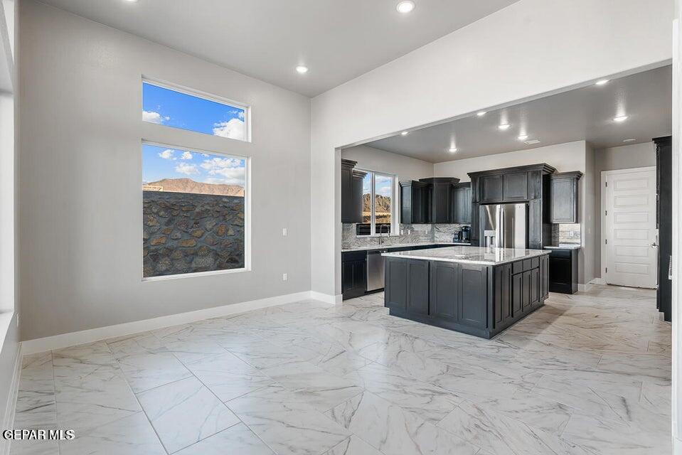7353 Cimarron Rim Road El Paso, TX 79911 - Photo 7 of 30 a large kitchen with a stove a kitchen island a refrigerator and a sink