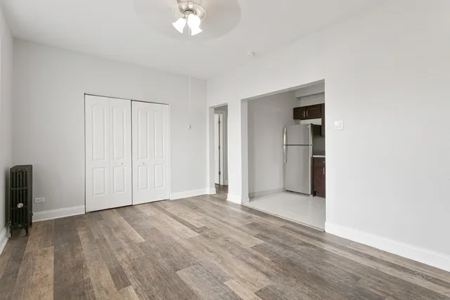 a view of empty room with wooden floor