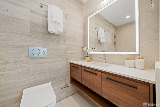 a bathroom with a sink a toilet and mirror