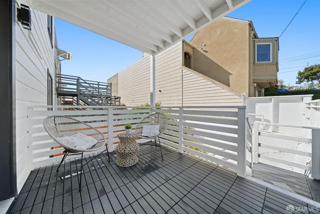 a roof deck view with table and chairs and wooden floor