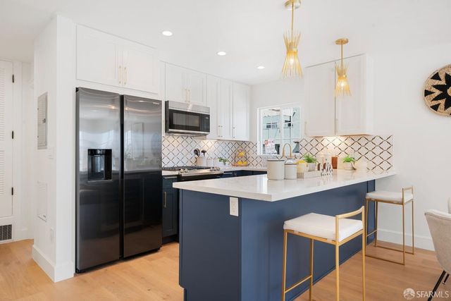 a kitchen with kitchen island a counter top space cabinets and stainless steel appliances