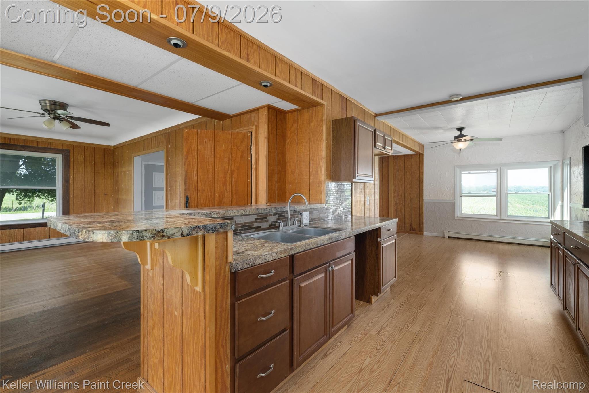 28780 School Section Road Richmond, MI 48062 - Photo 18 of 50 Kitchen island with a double basin stainless steel sink and a multi-toned countertop, complemented by dark wood-finish cabinetry