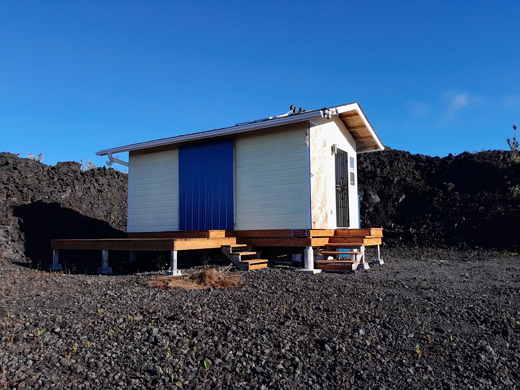 a backyard of a house with wooden fence and a bench
