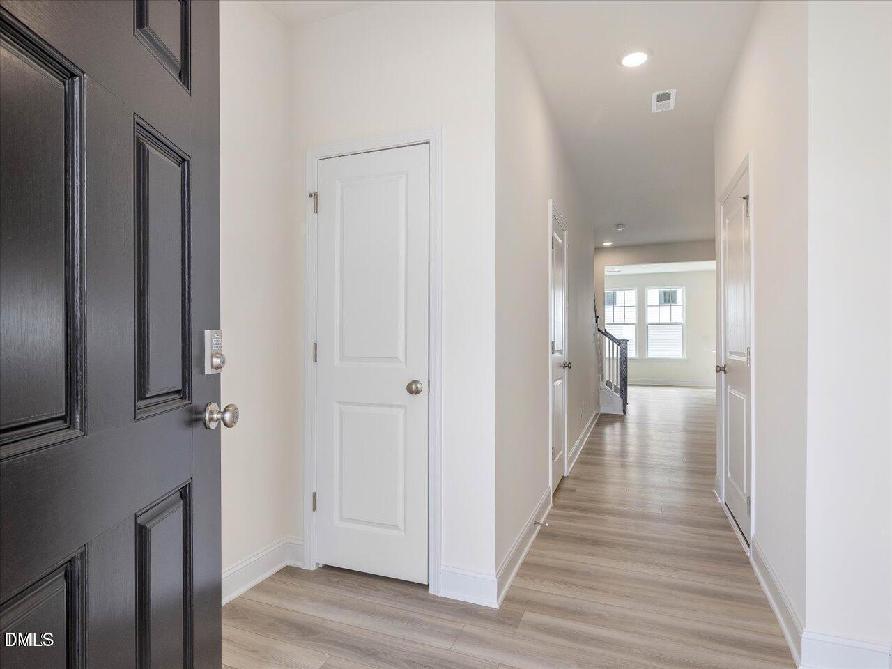 908 Kensley Grv Lane Fuquay-Varina, NC 27526 - Photo 4 of 37 a view of a hallway with wooden floor and closet area