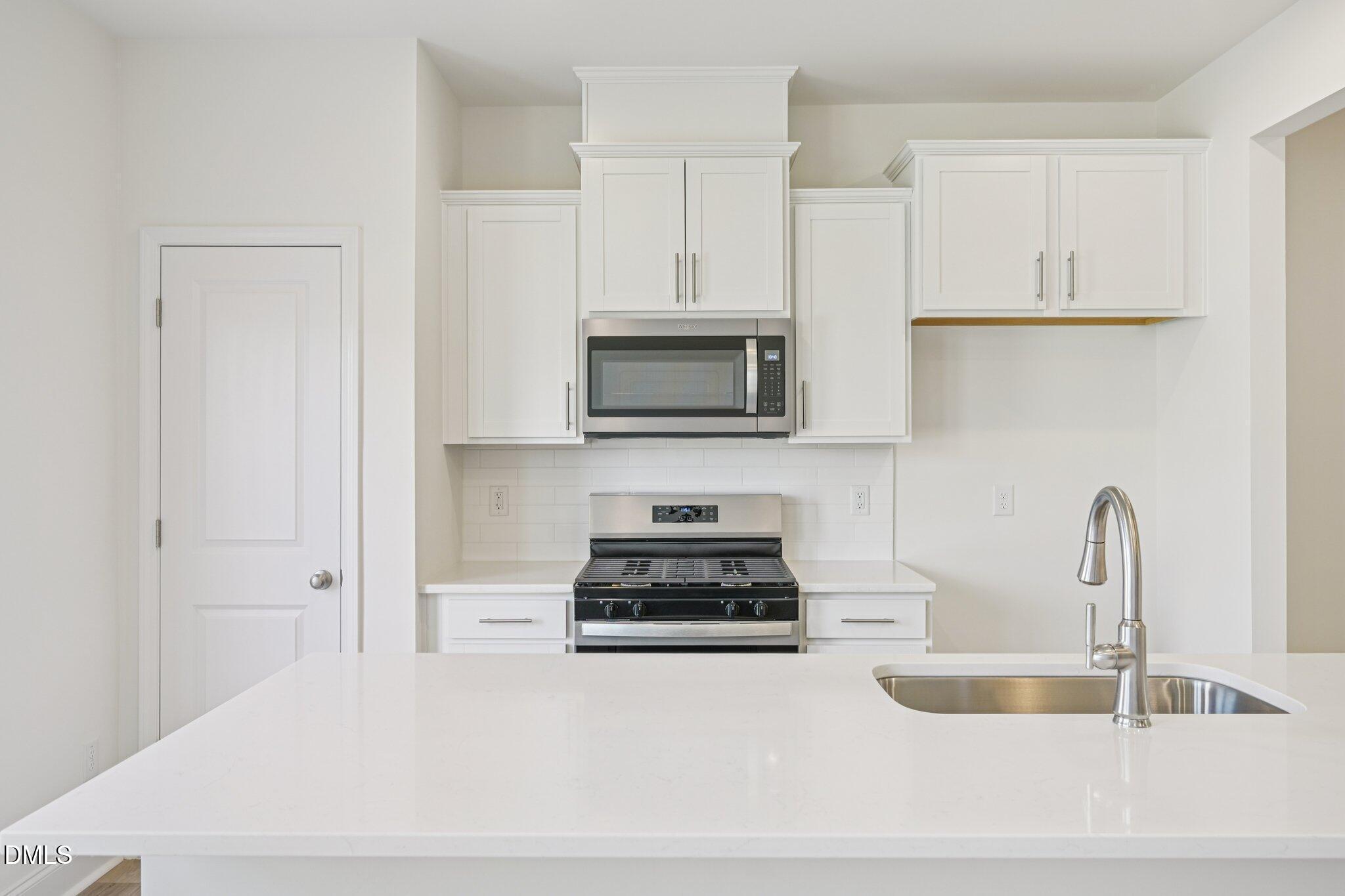 908 Kensley Grv Lane Fuquay-Varina, NC 27526 - Photo 9 of 37 a kitchen with white cabinets and appliances