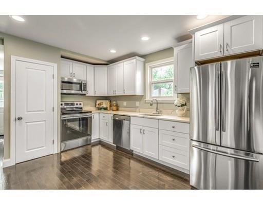 55 Cottage Road Boston, MA 02132 - Photo 6 of 30 a kitchen with kitchen island granite countertop white cabinets and refrigerator