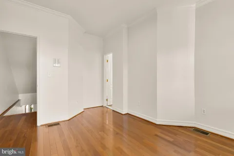 a view of an empty room with wooden floor