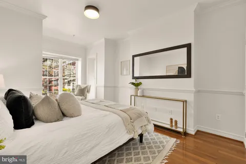 a bedroom with a bed and a flat tv screen on dresser