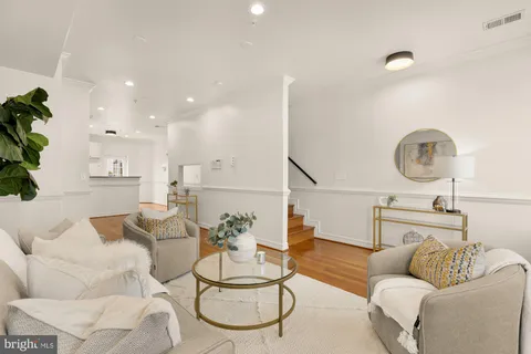 a living room with furniture a mirror and white walls