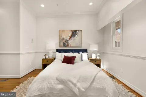 a bedroom with a bed and a painting on the wall