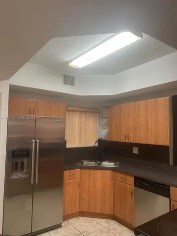 a kitchen with a refrigerator and a sink