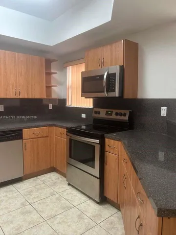 a kitchen with stainless steel appliances granite countertop a sink stove and microwave