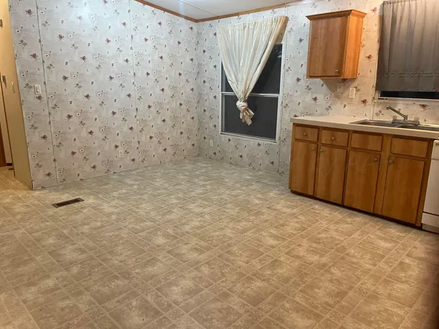 a kitchen with stainless steel appliances a sink a stove a refrigerator cabinets and a window