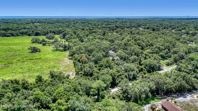 an aerial view of a houses with yard and lake view