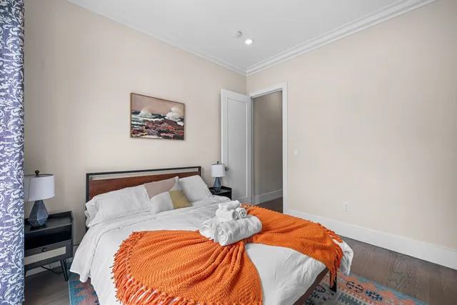 a bedroom with a bed and a painting on the wall