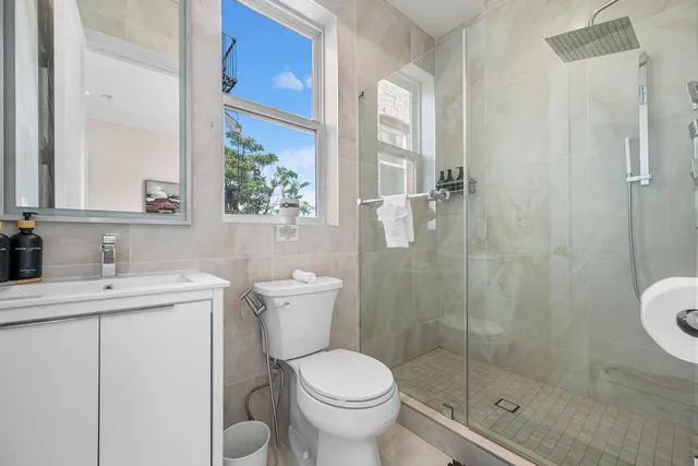a bathroom with a granite countertop toilet a sink and a mirror