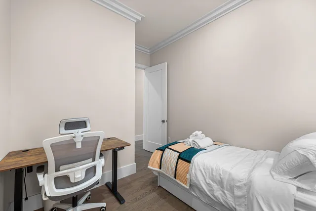 a bedroom with a bed a chair and a table