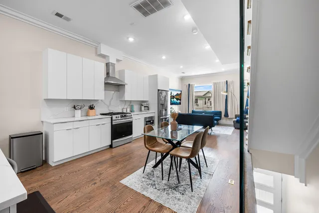 a kitchen with white cabinets and chairs
