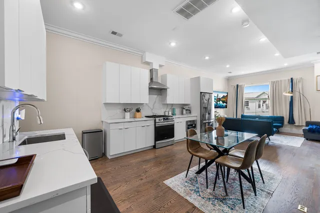a kitchen with a table chairs a sink dishwasher stove and cabinets