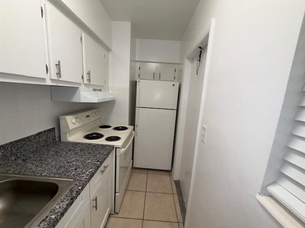 119 Northeast 5th Street, Unit 3 Pompano Beach, FL 33060 - Photo 2 of 8 a kitchen with a stove a refrigerator and a sink
