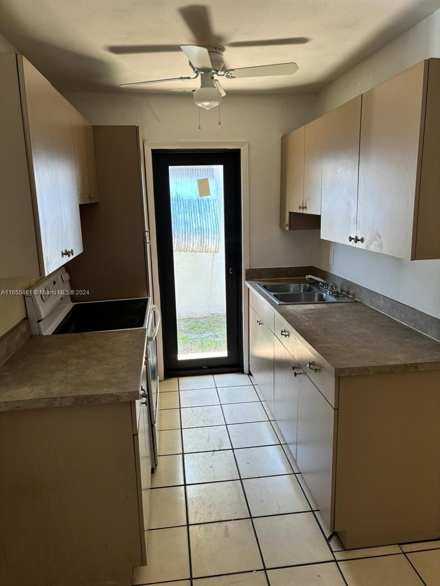 204 Southwest 2nd Place, Unit 2 Dania Beach, FL 33004 - Photo 11 of 13 a kitchen with granite countertop a sink a stove and cabinets