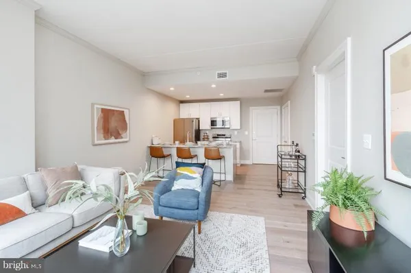 a living room with furniture kitchen view and a potted plant