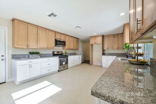 240 West Benson Avenue Ridgecrest, CA 93555 - Photo 7 of 29 a kitchen with stainless steel appliances granite countertop a stove a sink and a refrigerator
