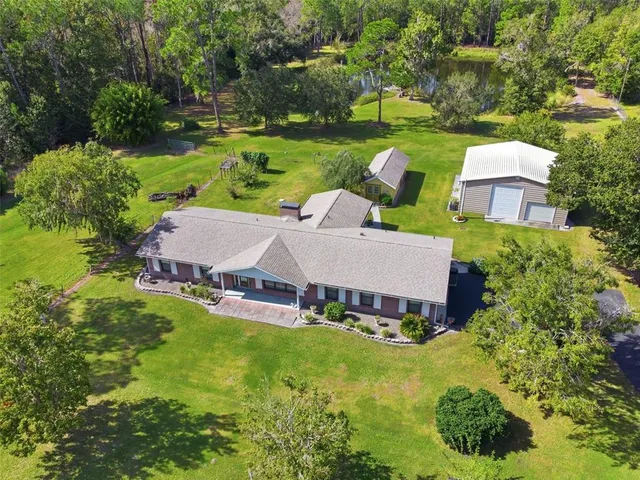 an aerial view of a house with garden space and a swimming pool