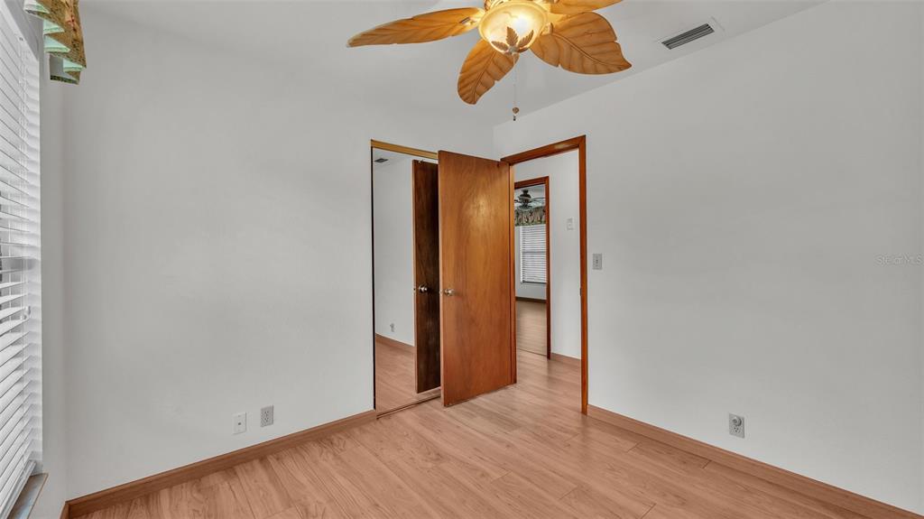9240 Moore Road Lakeland, FL 33809 - Photo 29 of 61 an empty room with a chandelier fan and wooden floor