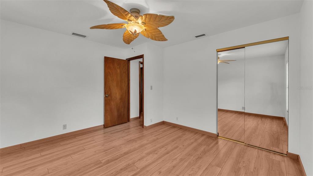 9240 Moore Road Lakeland, FL 33809 - Photo 31 of 61 an empty room with wooden floor and a ceiling fan