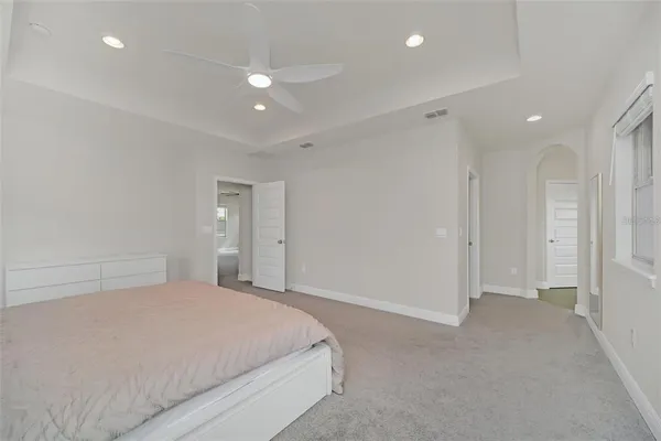 a spacious bedroom with a bed and a ceiling fan